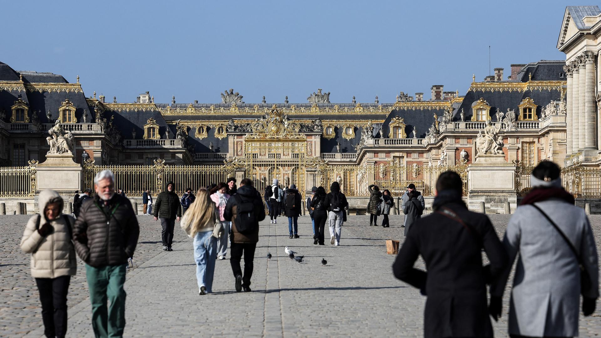 Menschen laufen auf den Eingang von Schloss Versailles zu. Menschen laufen auf den Eingang von Schloss Versailles zu.
