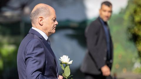 26.08.2024, Solingen: Bundeskanzler Olaf Scholz (SPD) legt eine Blume an einer Kirche in der Nähe des Tatorts ab. 