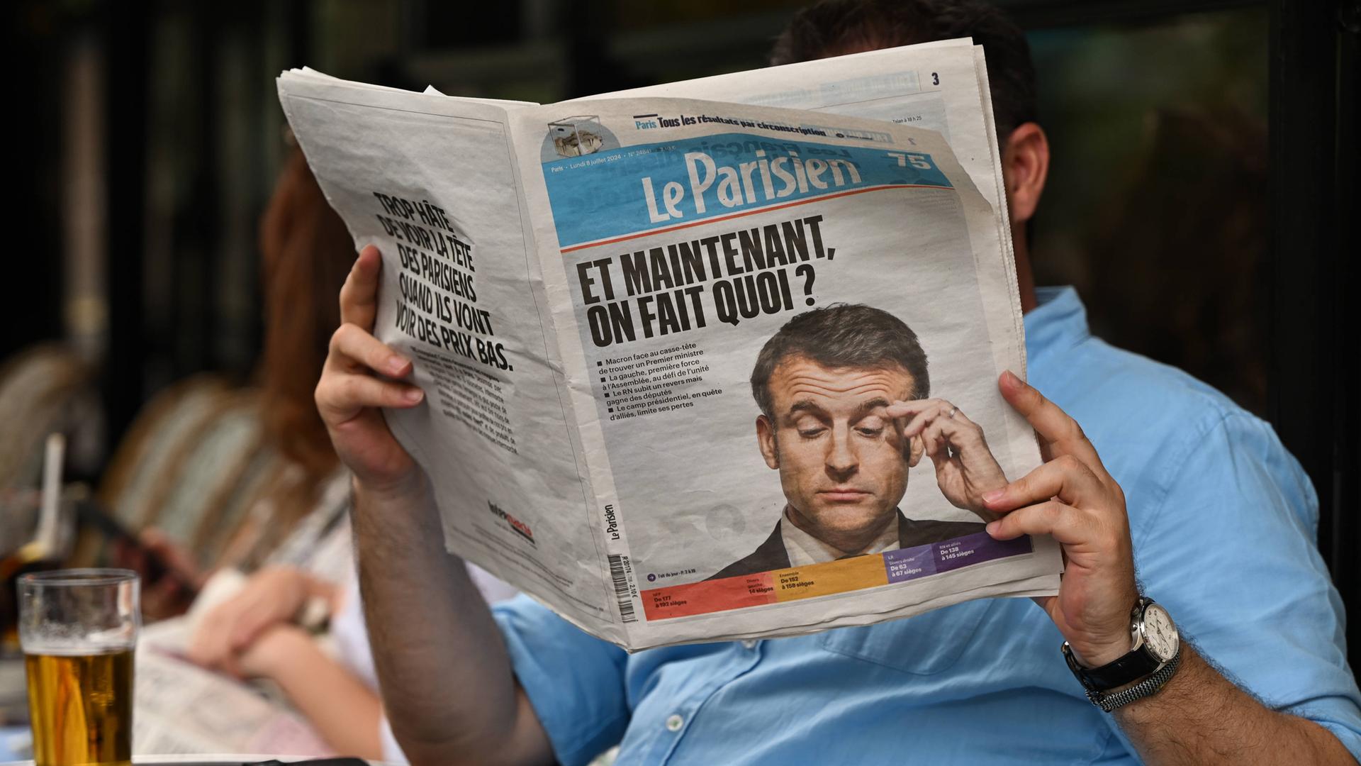 Ein Mann liest die Zeitung „Le Parisien“ am Tag nach der zweiten Runde der französischen Parlamentswahlen.