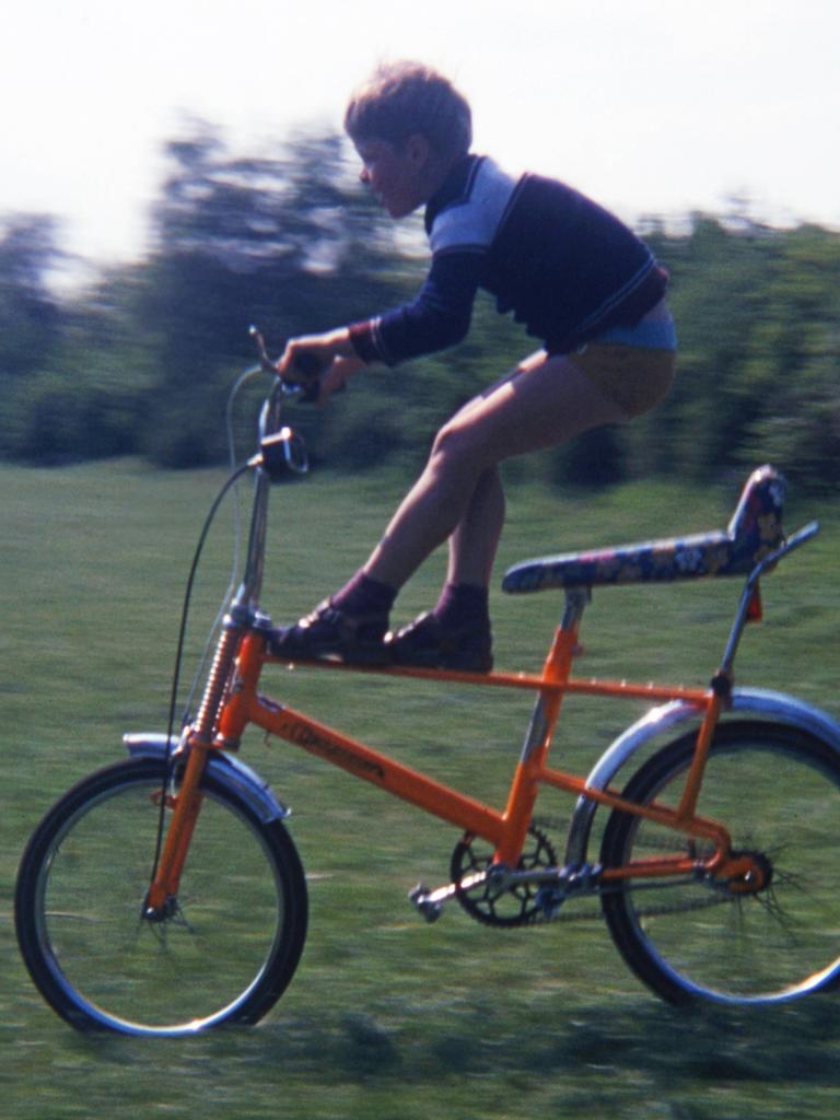 Ein Kind fährt mit einem orangenen Bonanza-Fahrrad über die Wiese.