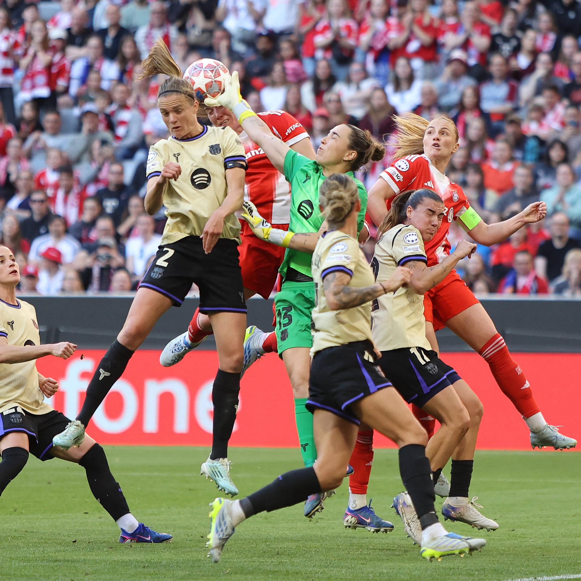 Halbfinale der Champions League der Frauen: Bayern München gegen Barcelona; Spielerinnen beider Teams springen nach dem Ball, der hoch durch die Luft fliegt.