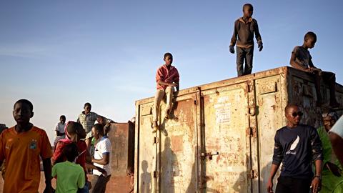 Junge Menschen aus Mali stehen auf einem Container am Niger in Segou.
