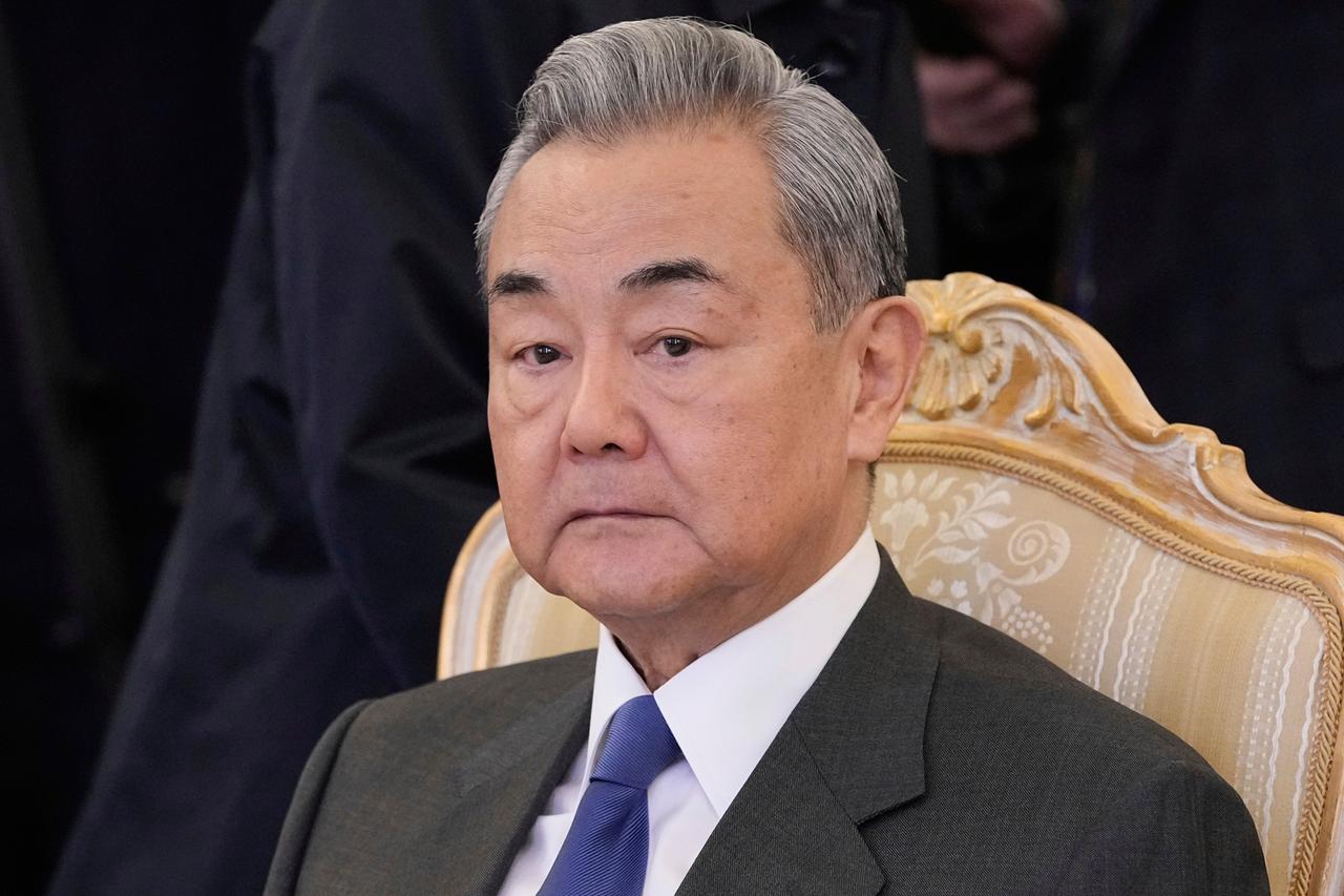 Der chinesische Außenminister Wang Yi sitzt auf einem Stuhl und schaut ernst.