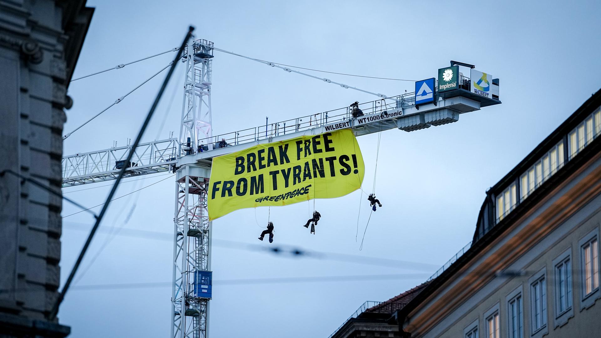 Aktivisten der Umweltschutzorganisation Greenpeace seilen sich von einem Kran mit einem Banner mit der Aufschrift "Break free from tyrants" in der Nähe der 62. Münchner Sicherheitskonferenz (MSC) ab. Aktivisten der Umweltschutzorganisation Greenpeace seilen sich von einem Kran mit einem Banner mit der Aufschrift "Break free from tyrants" in der Nähe der 62. Münchner Sicherheitskonferenz (MSC) ab.