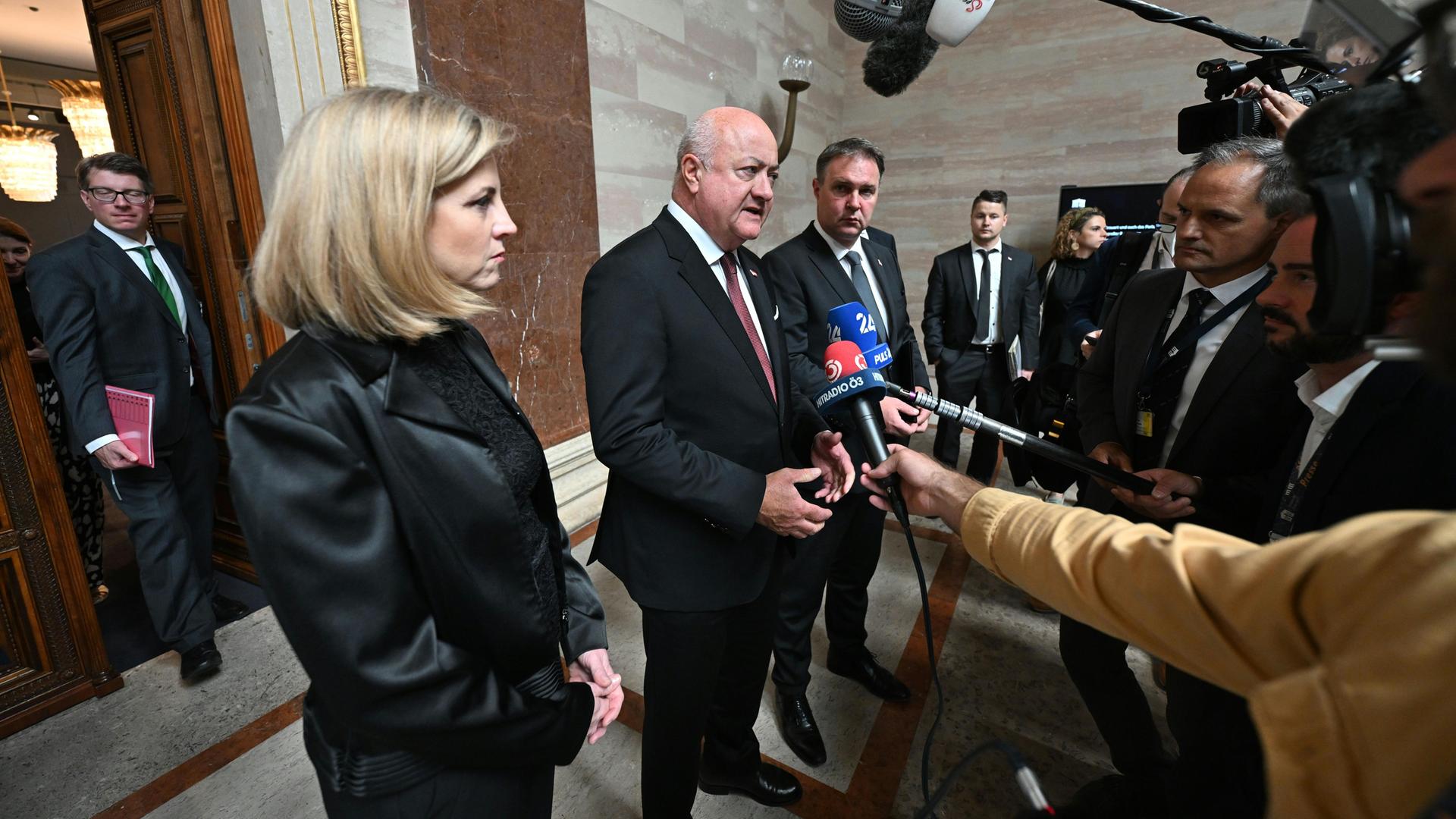 Außenministerin Beate Meinl-Reisinger (NEOS), Bundeskanzler Christian Stocker (M, ÖVP), Vizekanzler Andreas Babler (SPÖ) sprechen in Mikrofone anlässlich einer Sitzung des Nationalen Sicherheitsrats im Parlament in Wien.