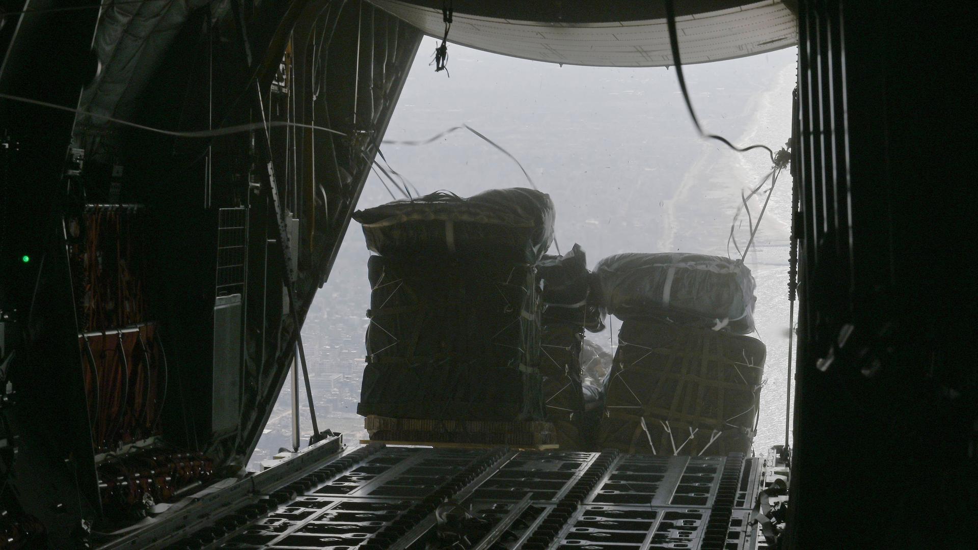 Pakete mit Hilfsgütern für Gaza werden aus einem Flugzeug geworfen.