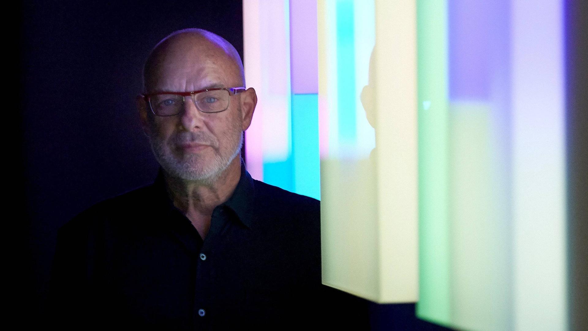 Brian Eno vor einer bunten LED-Installation.