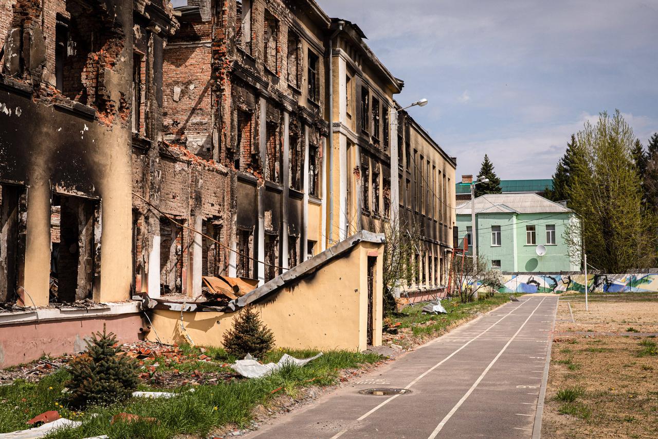 Außenansicht einer zerstörten Schule in Charkiw im Nordosten der Ukraine. Die Fenster fehlen, die Fassade ist von Rauch geschwärzt.