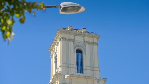 Der Kirchturm der Garnisonkirche in Potsdam vor einem blauen Himmel.