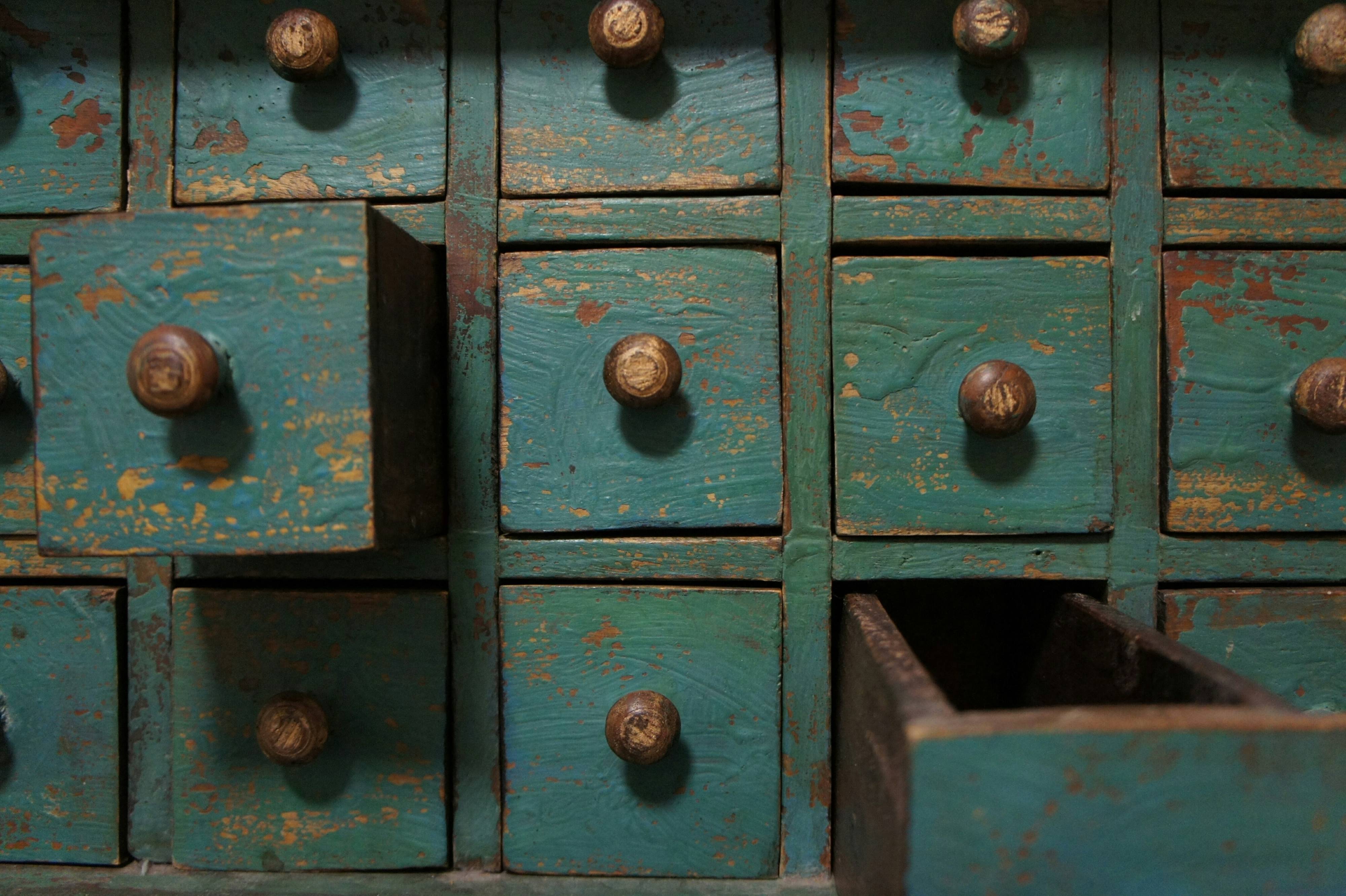 Blau angestrichene alte Vintage-Kommode mit Schubladen. Zwei Schubladen sind geöffnet.