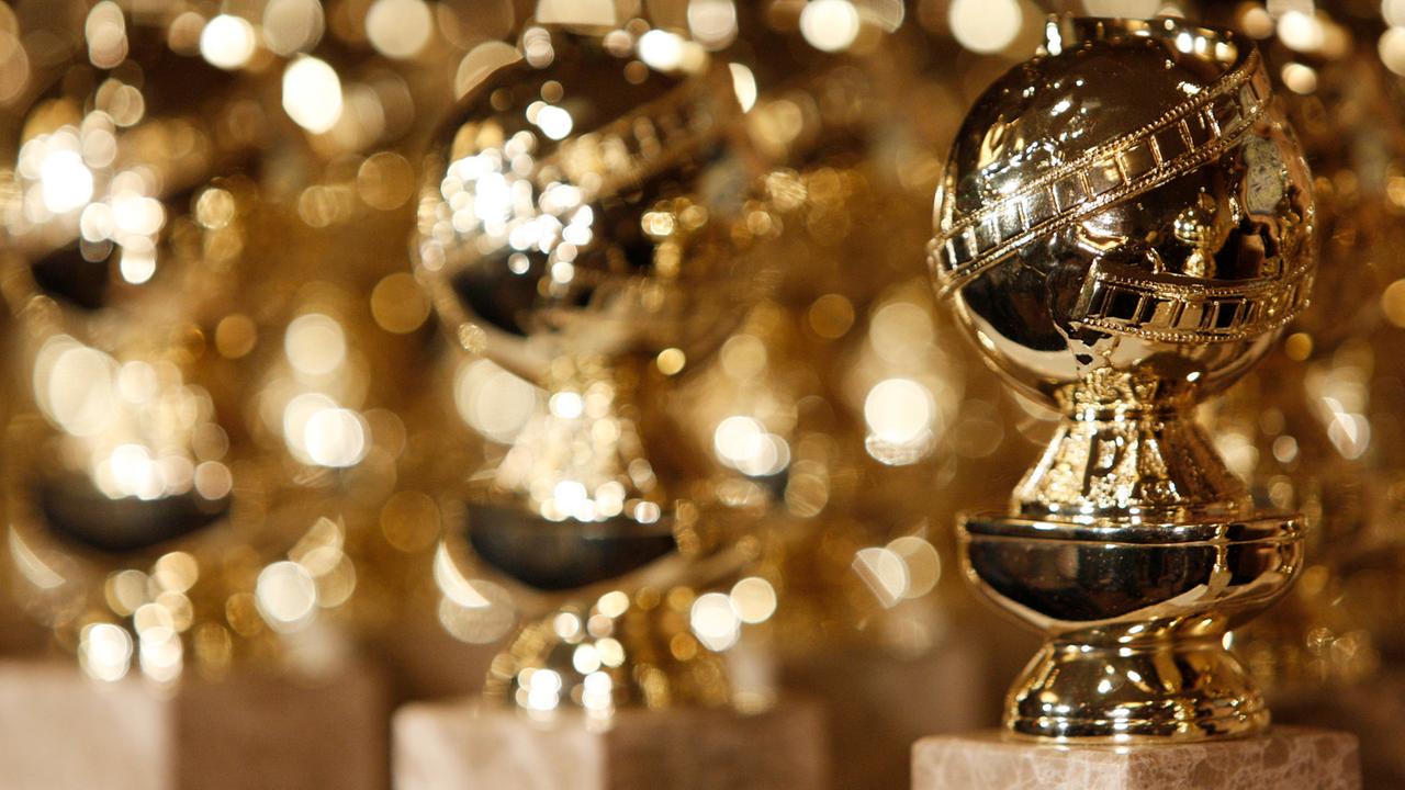 Das Bild zeigt mehrere Golden-Globe-Statuen, die nebeneinander stehen.