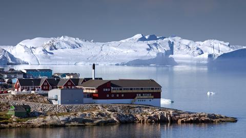Eisberge und bunte Häuser in der Stadt Ilulissat in Grönland