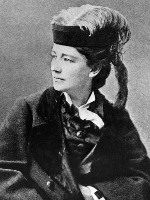 Schwarzweiß-Fotografie von Victoria Woodhull um 1890 - sie trägt einen Pferdeschwanz und einen Hut mit Feder