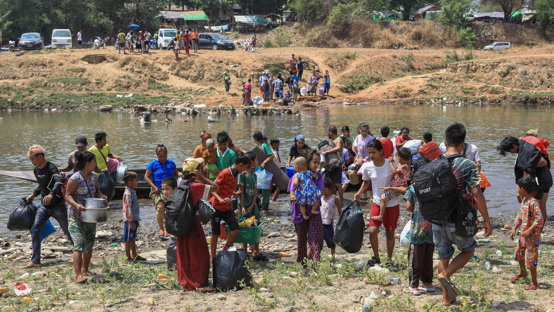Nach dem Angriff der Rebellengruppen auf die Stadt Myawaddy flüchten die Menschen über einen Fluss in die thailändische Provinz Tak.