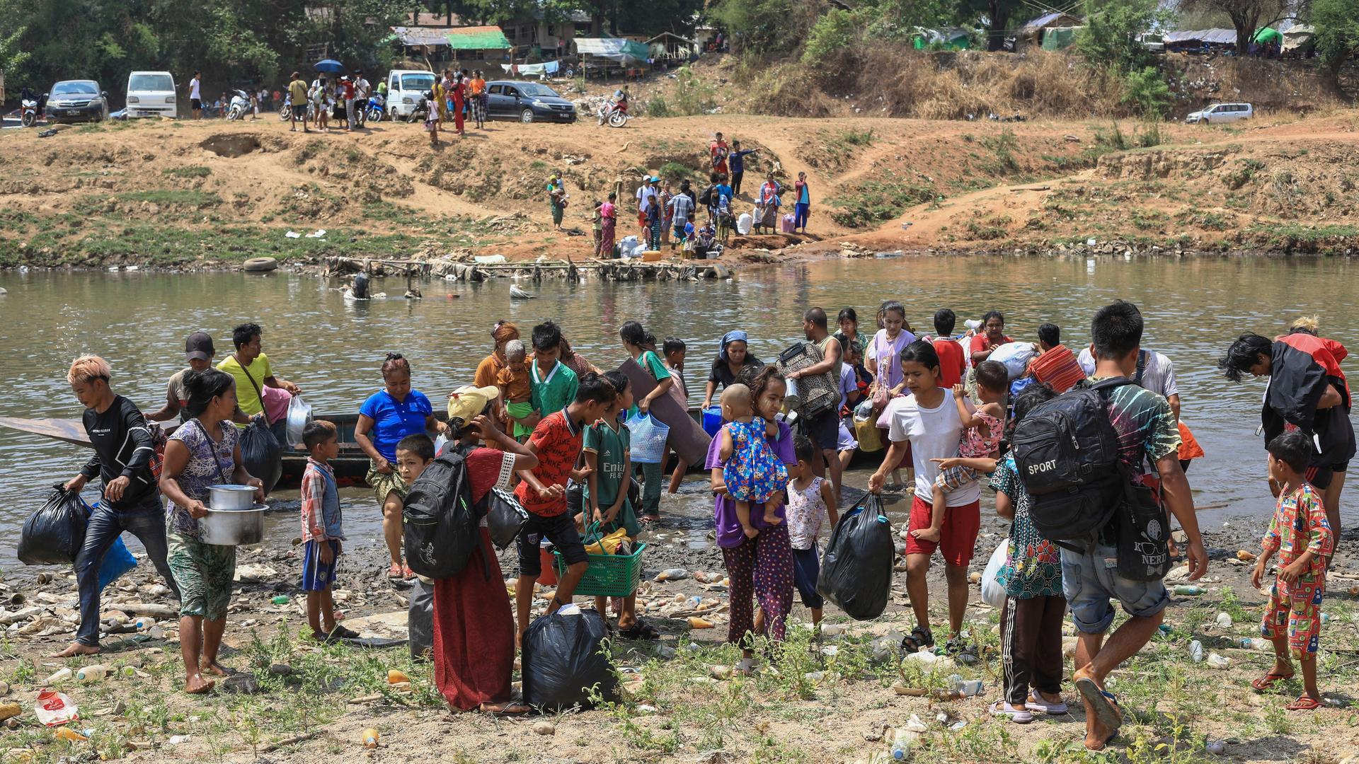 Nach dem Angriff der Rebellengruppen auf die Stadt Myawaddy flüchten die Menschen über einen Fluss in die thailändische Provinz Tak. Nach dem Angriff der Rebellengruppen auf die Stadt Myawaddy flüchten die Menschen über einen Fluss in die thailändische Provinz Tak.