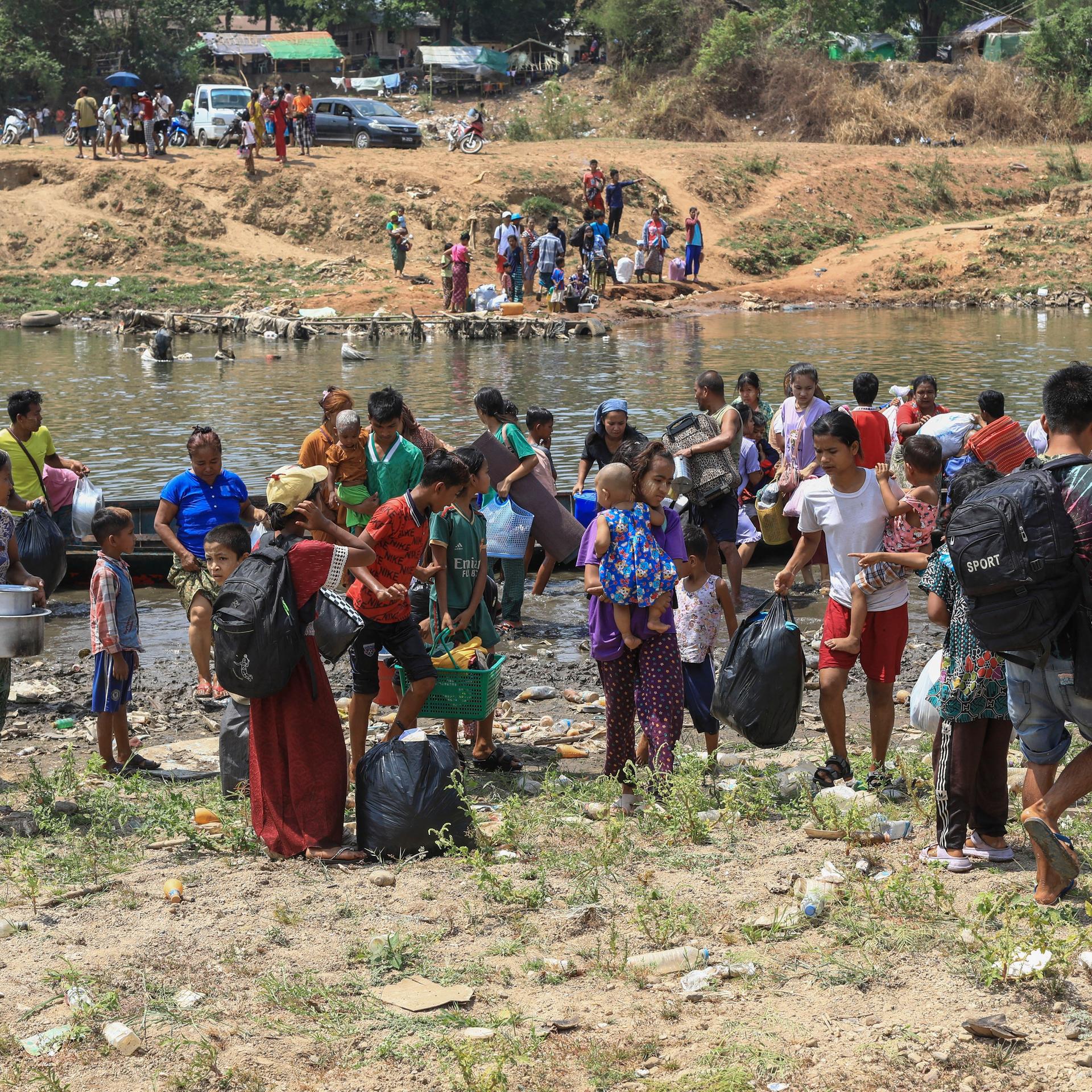 Nach dem Angriff der Rebellengruppen auf die Stadt Myawaddy flüchten die Menschen über einen Fluss in die thailändische Provinz Tak.