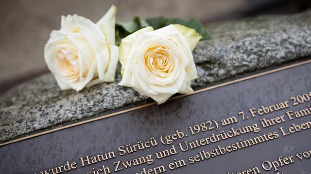 Zwei weiße Rose liegen auf einem Gedenkstein, der am Tatort in der Oberlandstrasse in Tempelhof-Berlin an Hatün Sürücü erinnert.