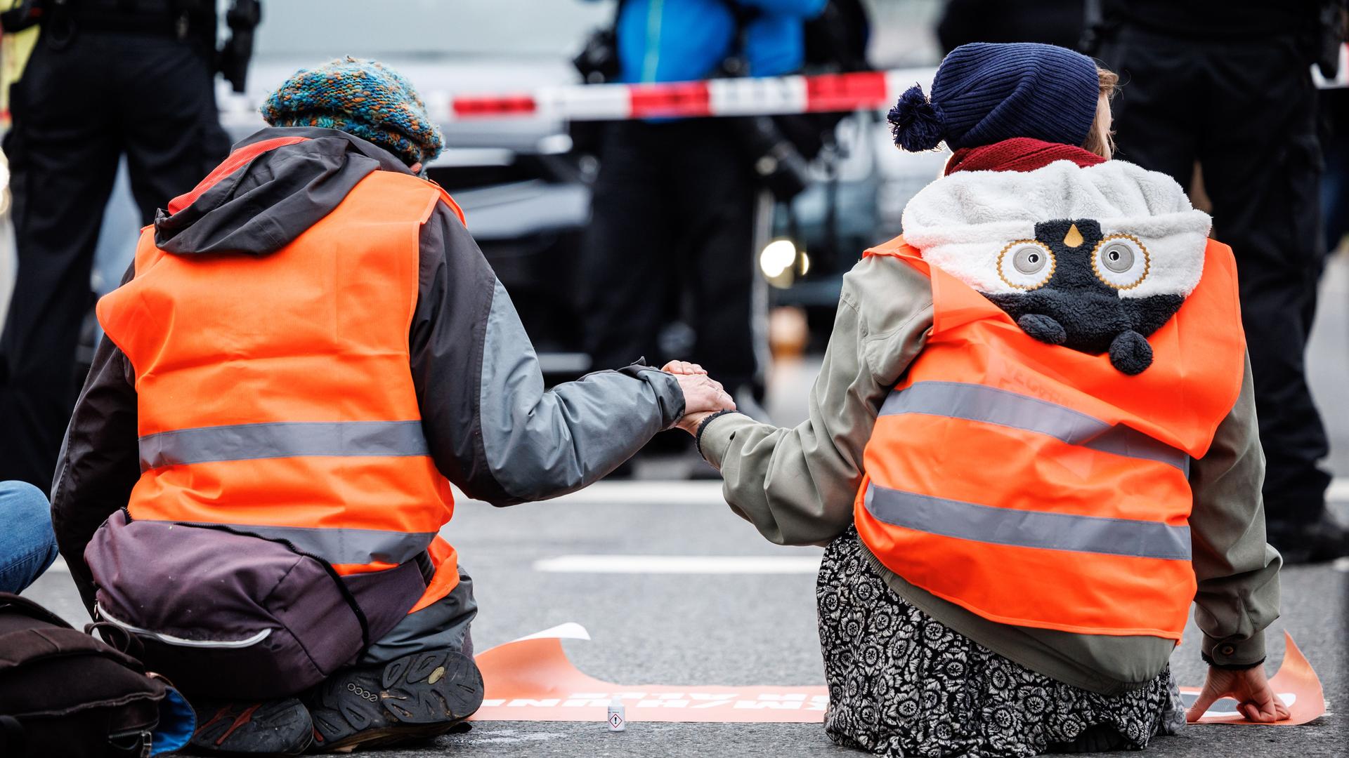 München: Aktivisten der Klimaschutz-Initiative "Letzte Generation" haben sich am Stachus mit ihren Händen auf die Straße geklebt.