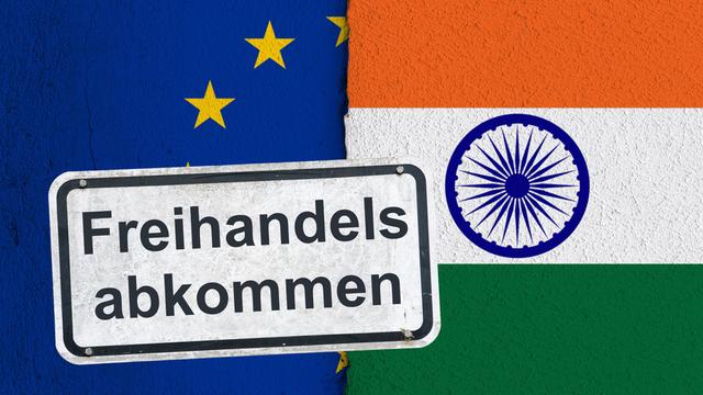 Ein weißes, verwittertes Hinweisschild mit der Aufschrift "Freihandelsabkommen", befestigt mit Schrauben an einer Wand mit der Flagge der Europäischen Union und der Nationalflagge der Republik Indien. Ein weißes, verwittertes Hinweisschild mit der Aufschrift "Freihandelsabkommen", befestigt mit Schrauben an einer Wand mit der Flagge der Europäischen Union und der Nationalflagge der Republik Indien.