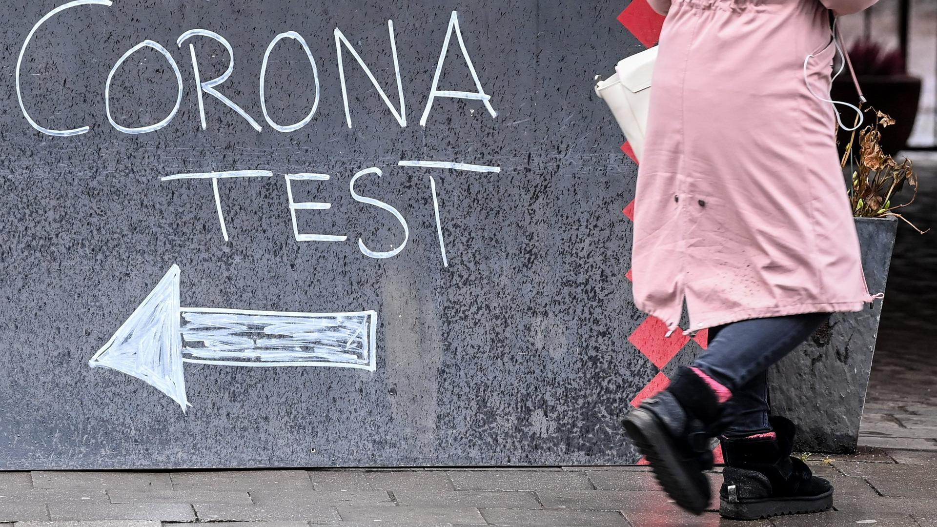 Eine Tafel weist den Weg zu einer Corona-Teststation. 