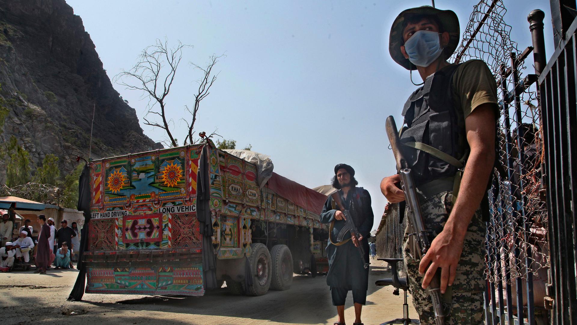 Ein pakistanischer Soldat und Kämpfer der Taliban stehen Wache an einem Grenzübergang zwischen Pakistan und Afghanistan in der Provinz Khyber Pakhtunkhwa. Ein pakistanischer Soldat und Kämpfer der Taliban stehen Wache an einem Grenzübergang zwischen Pakistan und Afghanistan in der Provinz Khyber Pakhtunkhwa.