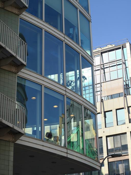 Moderne Bürogebäude spiegeln sich in der Glasfasse einer weiteren Gewerbeimmobilie, aufgenommen im Stadtteil Mitte in Berlin am 02.03.2018. Foto: Wolfram Steinberg/dpa