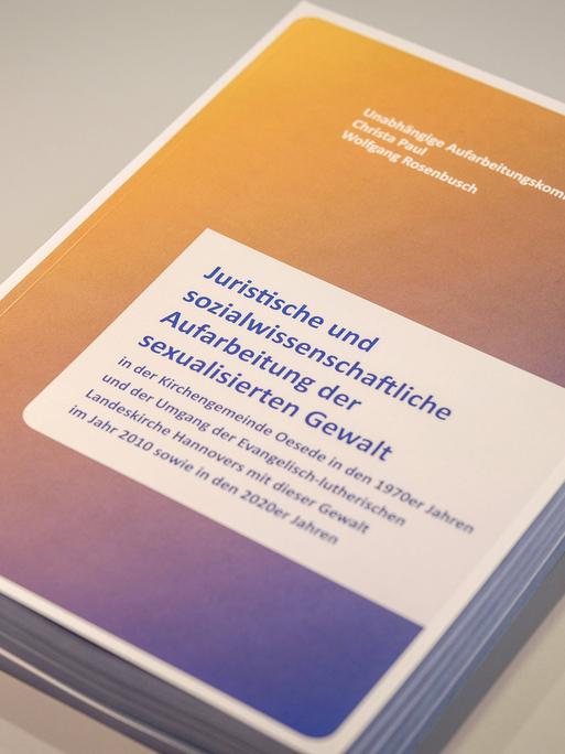 Foto des Abschlussberichts der unabhängigen Aufarbeitungskommission für Fälle sexualisierter Gewalt in der Kirchengemeinde Oesede in den Jahren 1972-1974, während einer Pressekonferenz am 27.02.2024 in Hannover. 