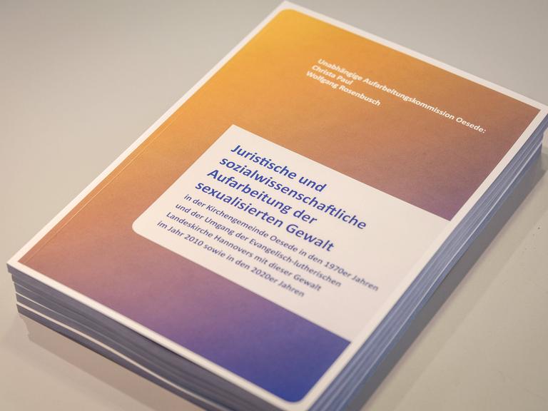 Foto des Abschlussberichts der unabhängigen Aufarbeitungskommission für Fälle sexualisierter Gewalt in der Kirchengemeinde Oesede in den Jahren 1972-1974, während einer Pressekonferenz am 27.02.2024 in Hannover. 