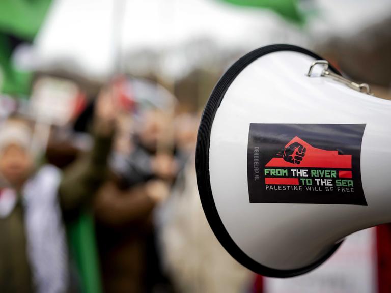Während einer Pro-Palästina-Demonstration wird ein Megaphon mit der Aufschrift "Vom Fluss bis zum Meer" hoch gehalten. Die Parole gilt als anti-semitisch, weil sie das Existenzrecht Israels in Frage stellt. 