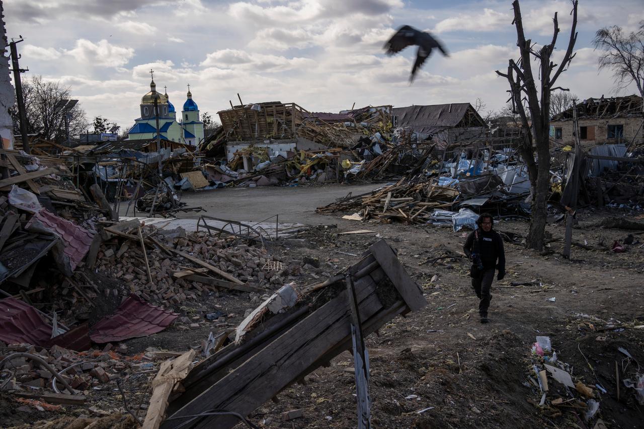 Ein Journalist läuft durch einen zerstörten Vorort der ukrainischen Hauptstadt Kiew.
