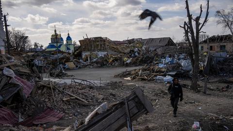 Ein Journalist läuft durch einen zerstörten Vorort der ukrainischen Hauptstadt Kiew.