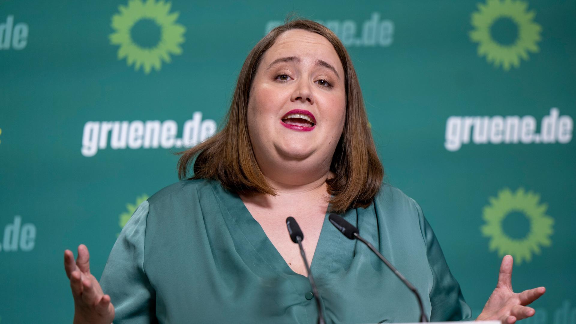 Das Foto zeigt die Bundesvorsitzende von Bündnis 90/Die Grünen, Ricarda Lang. Sie steht hinter zwei Mikrofonen. Hinter ihr das Logo der Grünen. Das Foto zeigt die Bundesvorsitzende von Bündnis 90/Die Grünen, Ricarda Lang. Sie steht hinter zwei Mikrofonen. Hinter ihr das Logo der Grünen.