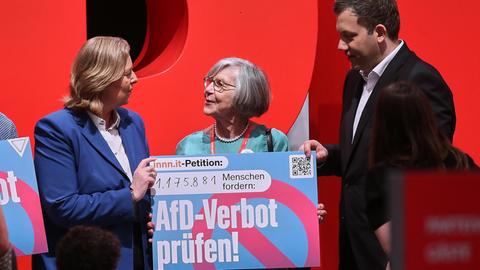 Bärbel Bas und Lars Klingbeil heben gemeinsam mit Betina Kern von Omas gegen Rechts ein Schild hoch mit der Aufschrift: "AfD-Verbot prüfen!"