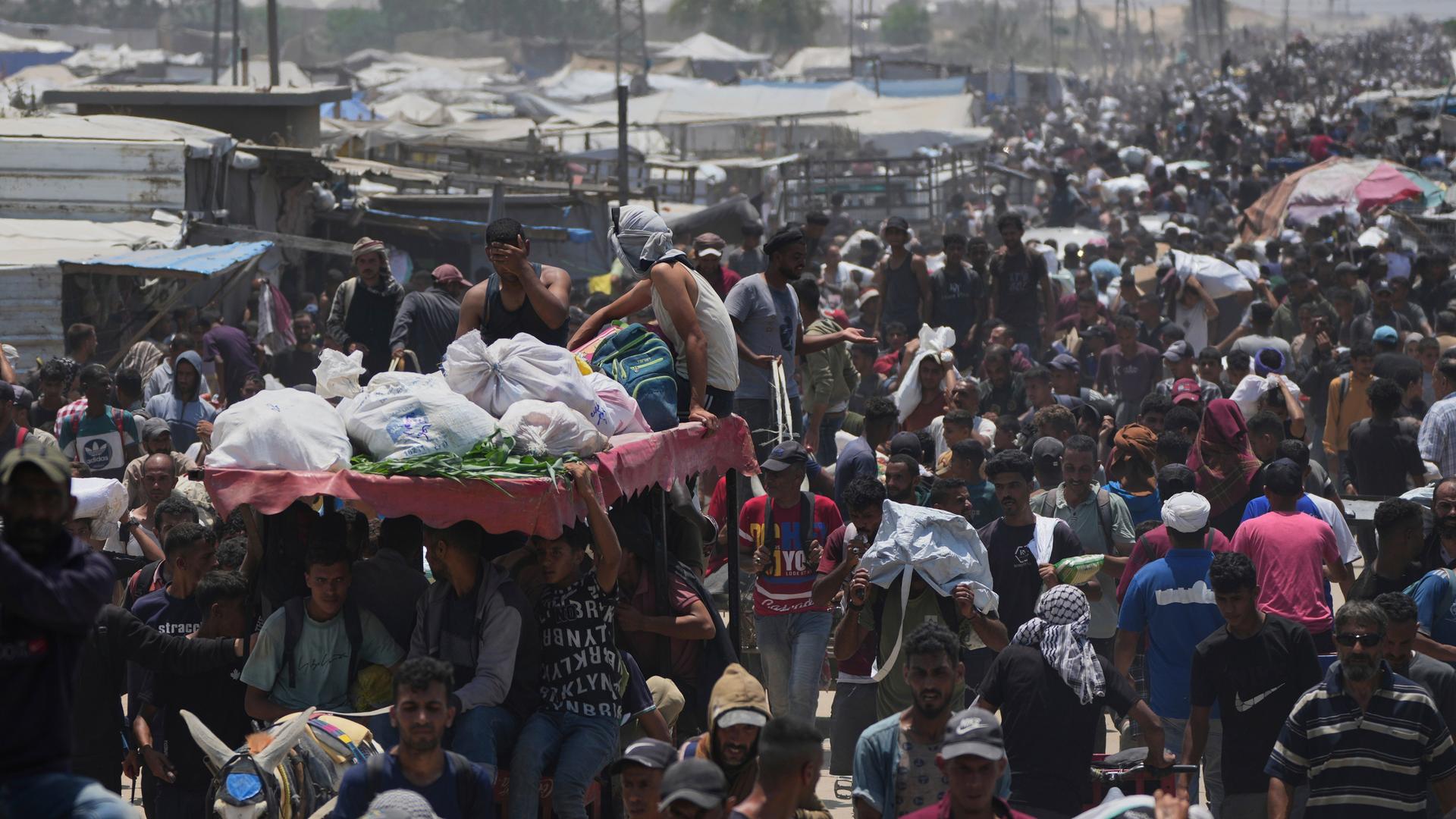 Palästinenser tragen Säcke mit Hilfsgütern und Essen, die von der Gaza Humanitarian Foundation geliefert wurden. Palästinenser tragen Säcke mit Hilfsgütern und Essen, die von der Gaza Humanitarian Foundation geliefert wurden.