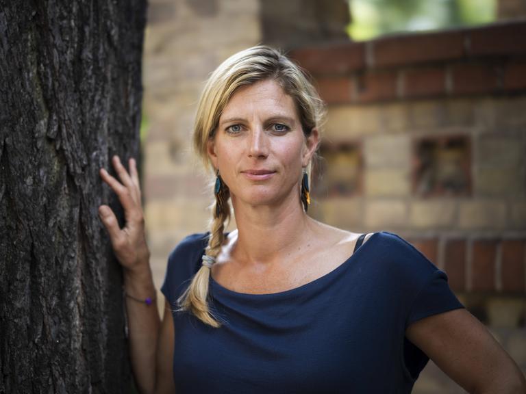 Die Ökonomin und Schriftstellerin Maja Göpel steht neben einem Baum.
