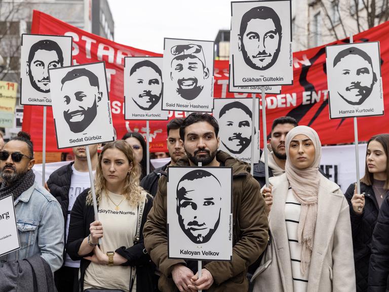 Menschen mit Porträts der Opfer und Spruchbändern gegen Rassismus nehmen am 17. Februar 2024 in Hanau an einem Protestmarsch zum Gedenken an die tödlichen Hanauer Schüsse von 2020 teil, vier Jahre nach dem Anschlag.