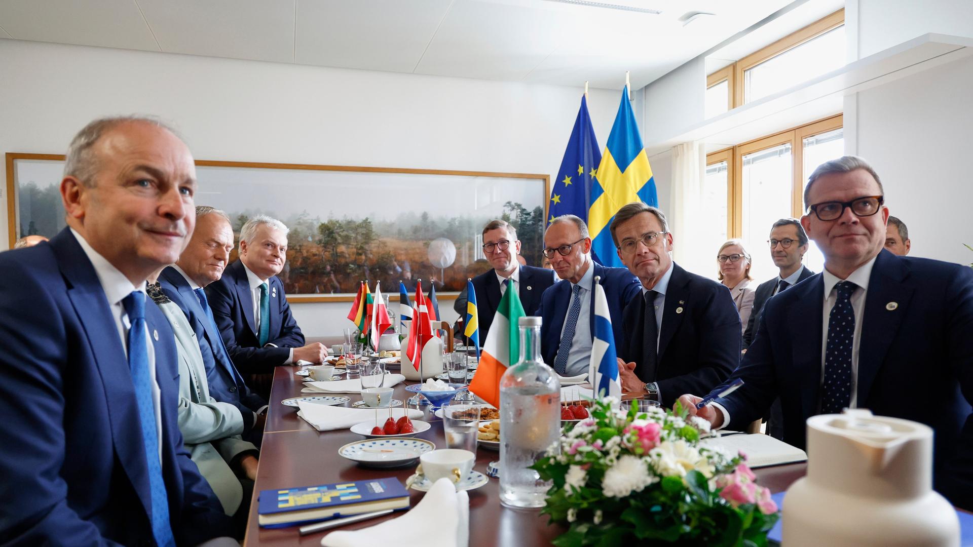 Irlands Ministerpräsident Michael Martin, Polens Ministerpräsident Donald Tusk, Litauens Präsident Gitanas Nauseda, Estlands Ministerpräsident Kristen Michal, Deutschlands Bundeskanzler Friedrich Merz, Schwedens Ministerpräsident Ulf Kristersson und Finnlands Ministerpräsident Petteri Orpo sitzen um einen Tisch herum. 