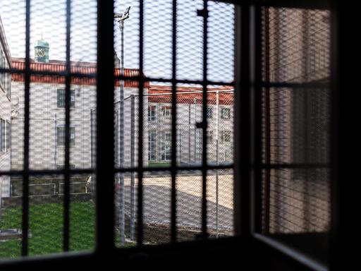 Blick aus einer Gefangenenzelle in der Justizvollzugsanstalt Nürnberg. Der Blick durch das vergitterte Fenster zeigt den Innenhof des Gefängnisses. 