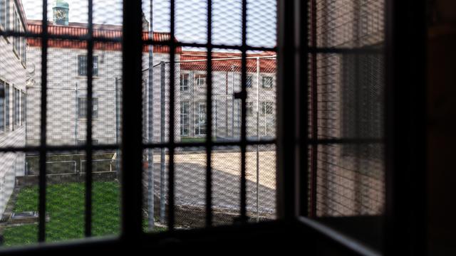 Blick aus einer Gefangenenzelle in der Justizvollzugsanstalt Nürnberg. Der Blick durch das vergitterte Fenster zeigt den Innenhof des Gefängnisses. 
