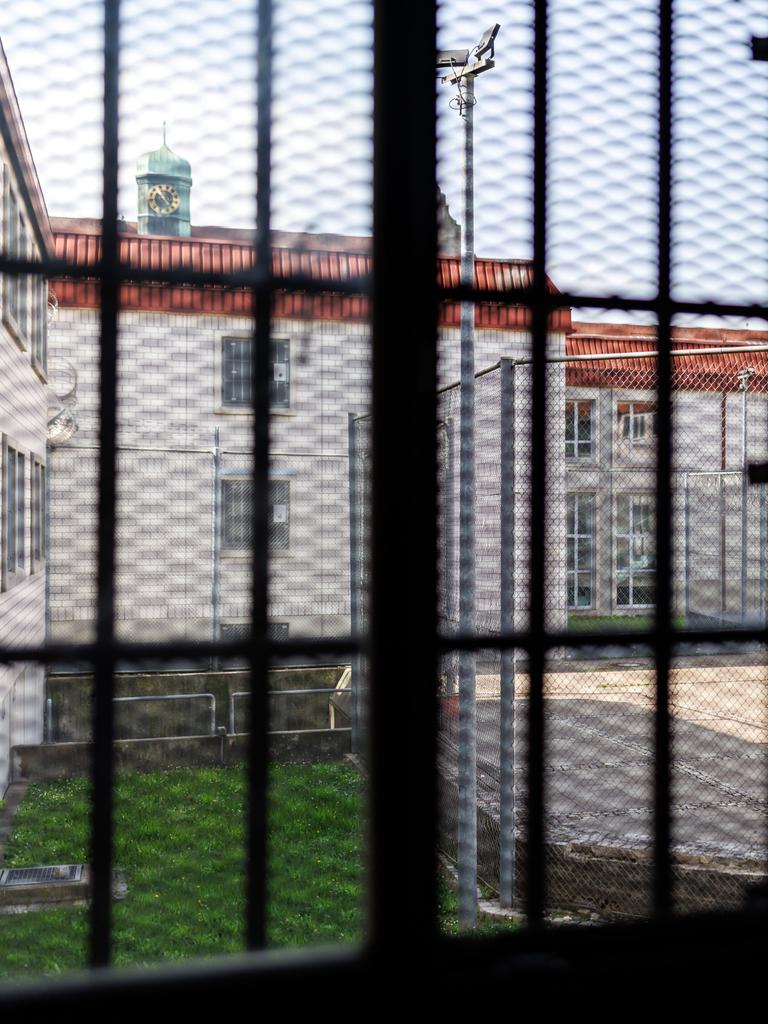 Blick aus einer Gefangenenzelle in der Justizvollzugsanstalt Nürnberg. Der Blick durch das vergitterte Fenster zeigt den Innenhof des Gefängnisses. 