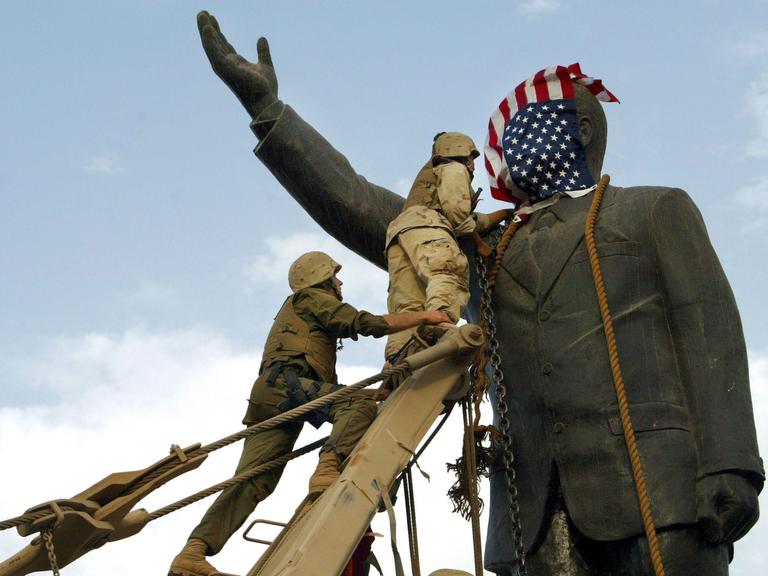 US-Truppen marschieren in die Innenstadt von Bagdad ein und stürzen am 9. April 2003 in Bagdad, Irak, die Statue von Saddam Hussein.