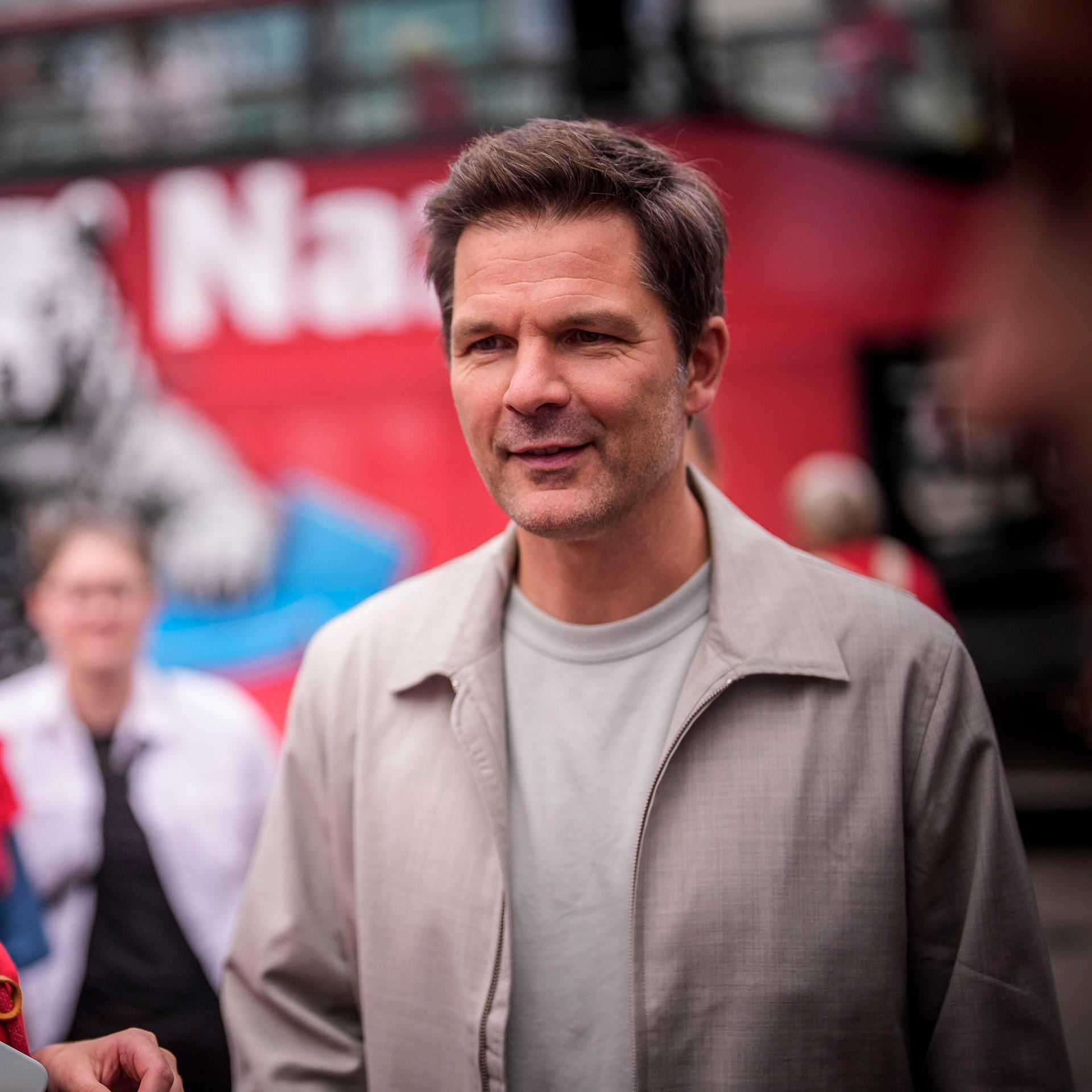Steffen Krach, der Spitzenkandidat der SPD, steht in Berlin auf einem Platz und spricht mit anderen Menschen. Krach ist ein Mann mittleren Alters, mit kurzen dunklen Haaren.