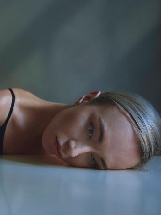 Der Kopf einer erschöpften Frau liegt auf einer Tischplatte (Symbolfoto)