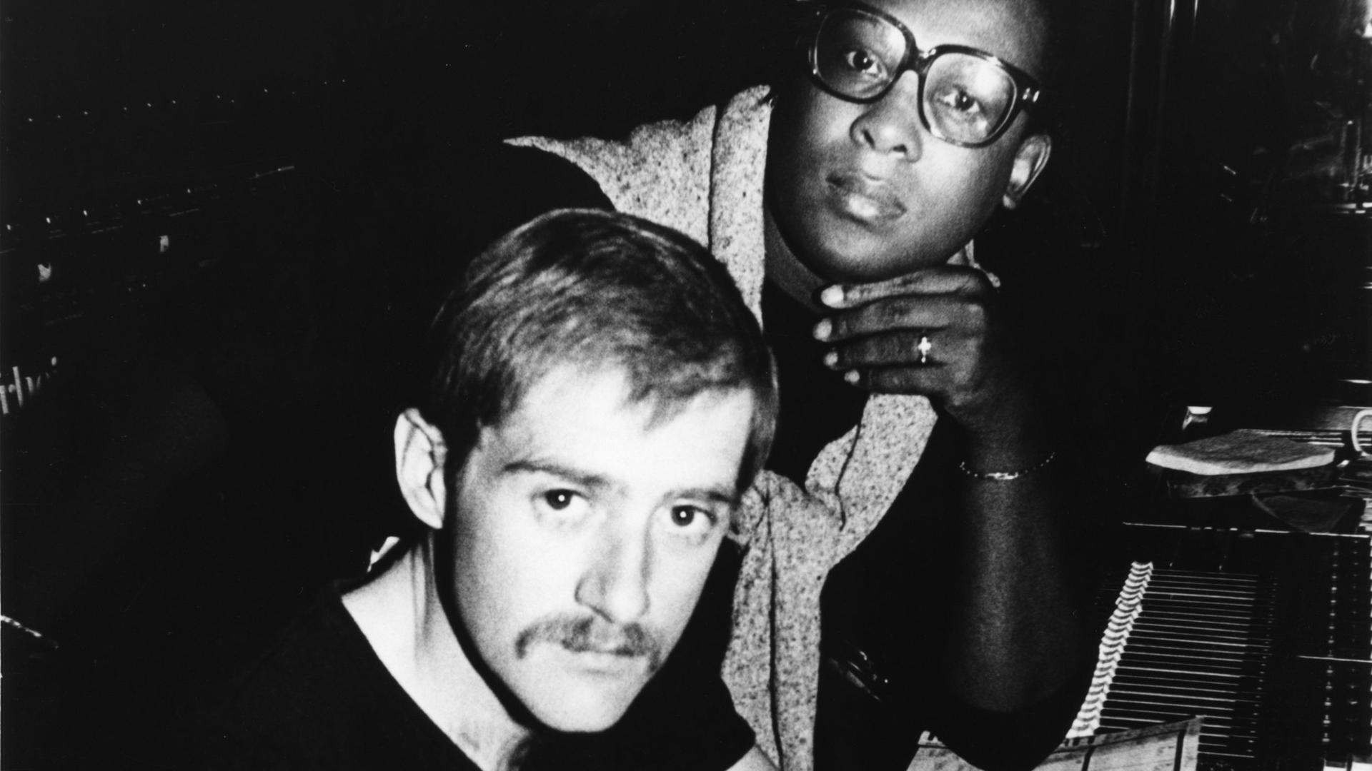 Der Produzent Patrick Cowley am Mischpult in einem Tonstudio, hinter ihm steht der Sänger Sylvester James, ca. 1980. 
