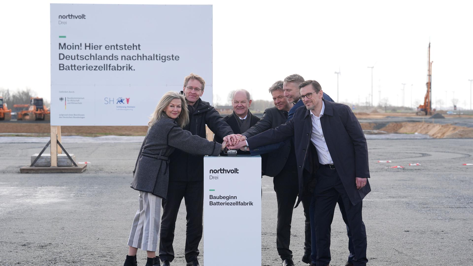Die schwedische Botschafterin in Deutschland neben Daniel Günther, Olaf Scholz, Robert Habeck, Peter Carlsson und Christofer Haux. Sie drücken gemeinsam den roten Knopf für den Start des Baus.