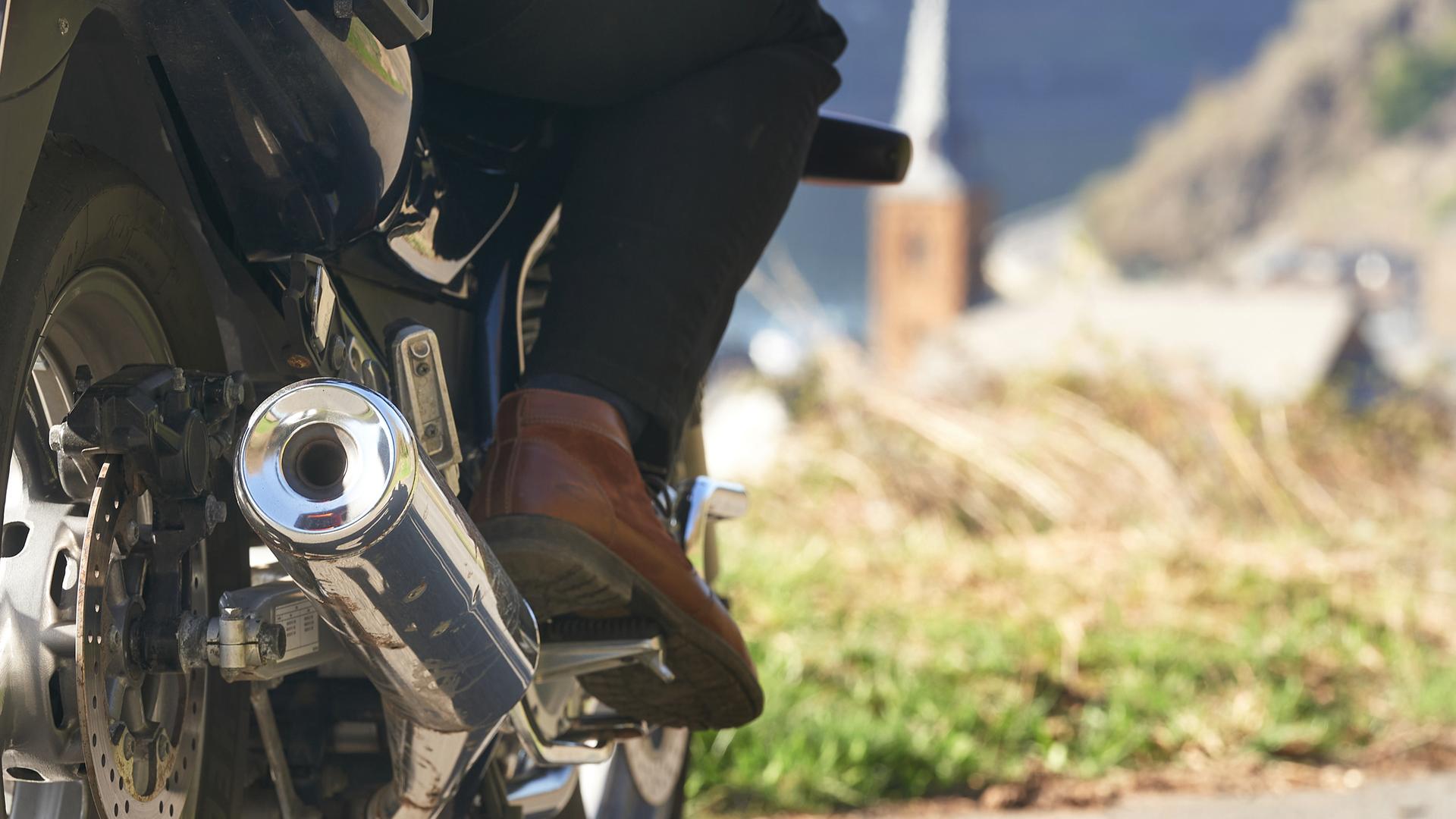 Ein Motorradfahrer fährt über eine Landstraße oberhalb von Alken an der Mosel.