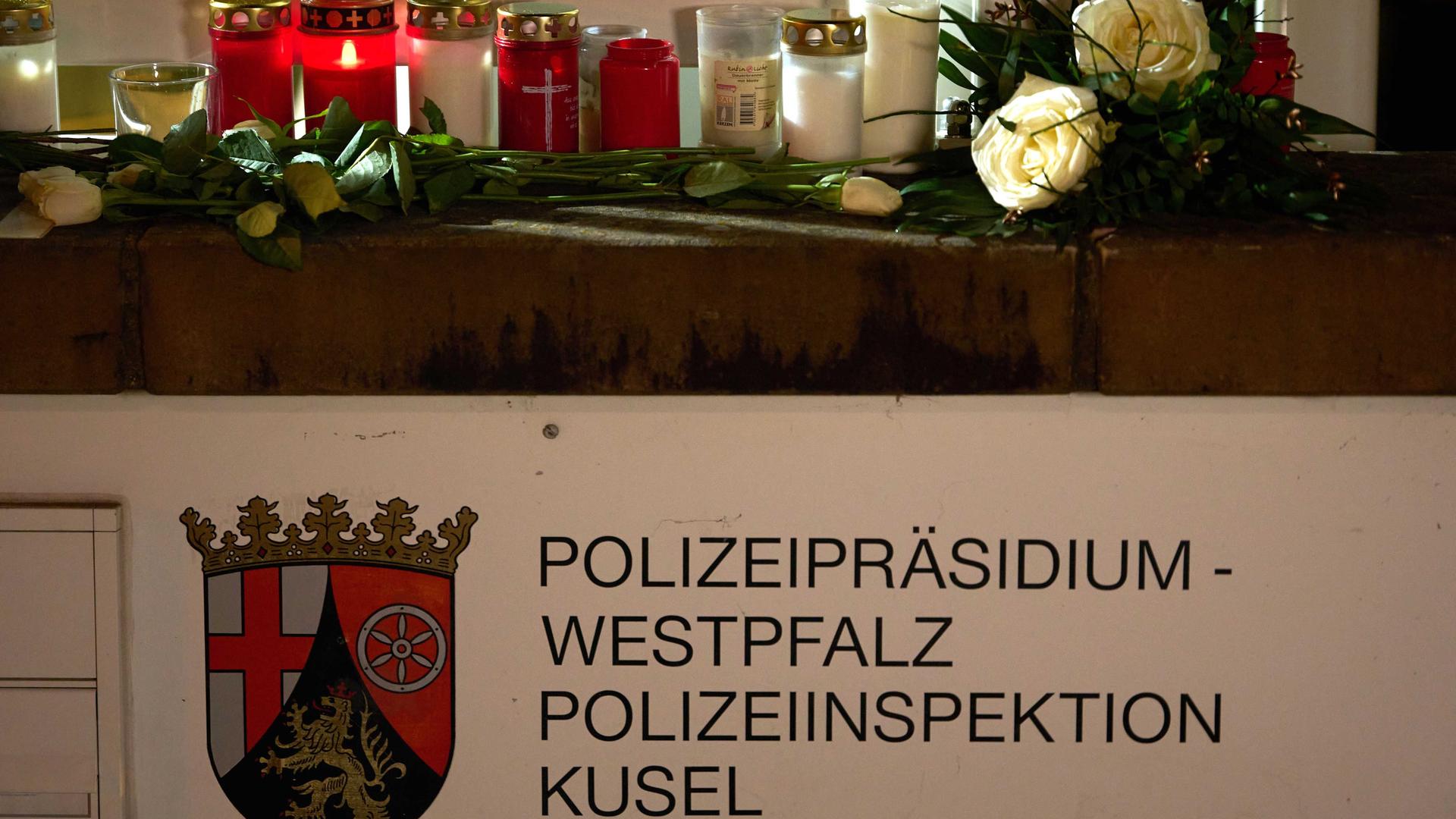 Kerzen und Blumen liegen vor dem Gebäude von dem Polizei-Präsidiu in der Stadt Kusel. 