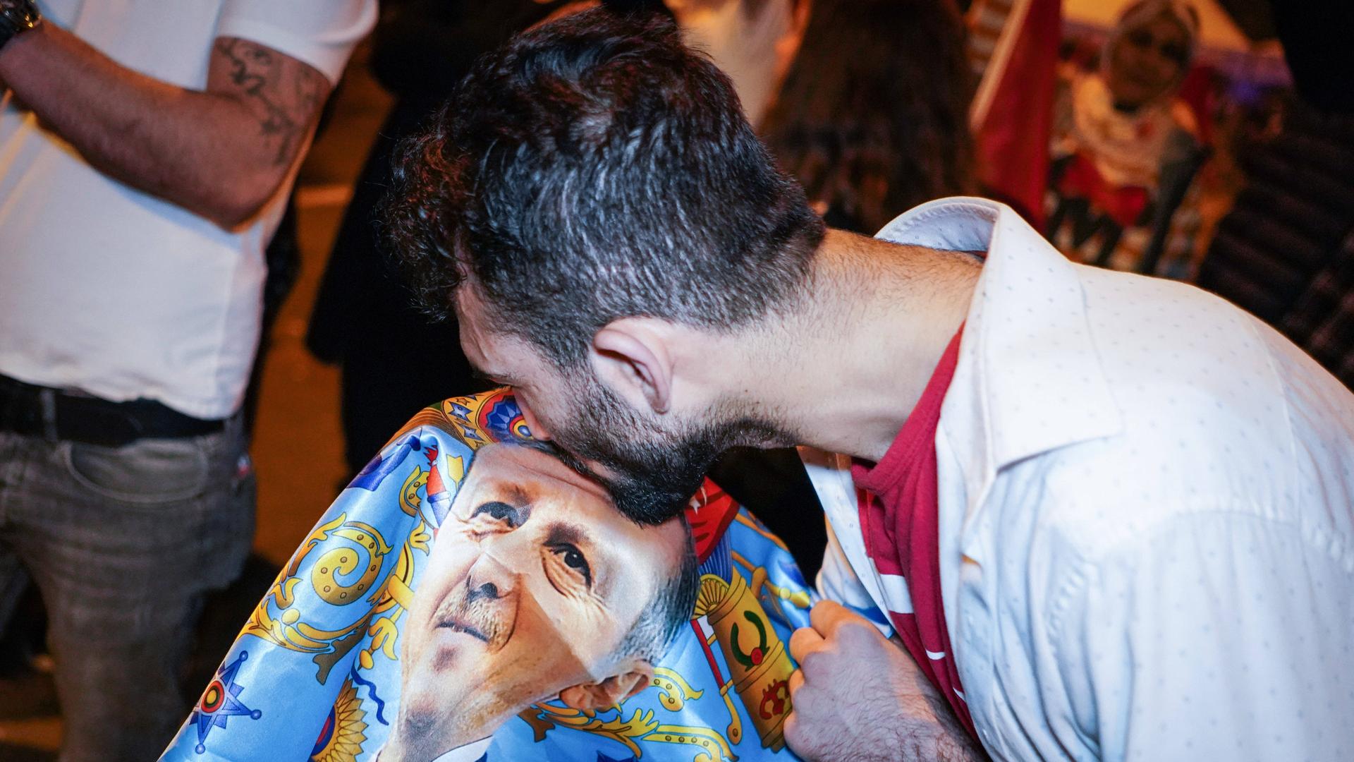 May 29, 2023, Ankara, Turkey: A man kisses the flag with the portrait of Recep Tayyip Erdogan during the celebration. According to the announcement of the Supreme Election Council, Recep Tayyip Erdoan, the candidate of the People s Alliance, won the 13th Presidential elections with 52 percent of the votes against his opponent, Kemal Klcdarolu, the candidate of the Nation Alliance, and became the President of Turkey again. Erdogan supporters met at the Presidential Residence after the results. Ankara Turkey - ZUMAs197 20230529_zaa_s197_026 Copyright: xTunahanxTurhanx