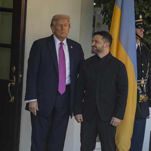 US-Präsident Donald Trump und der ukrainische Präsident Selenskyj stehen vor dem Weißen Haus. Selenskyi schaut zu Trump. Im Hintergrund sind US-Soldaten und die Landesfahne zu sehen.