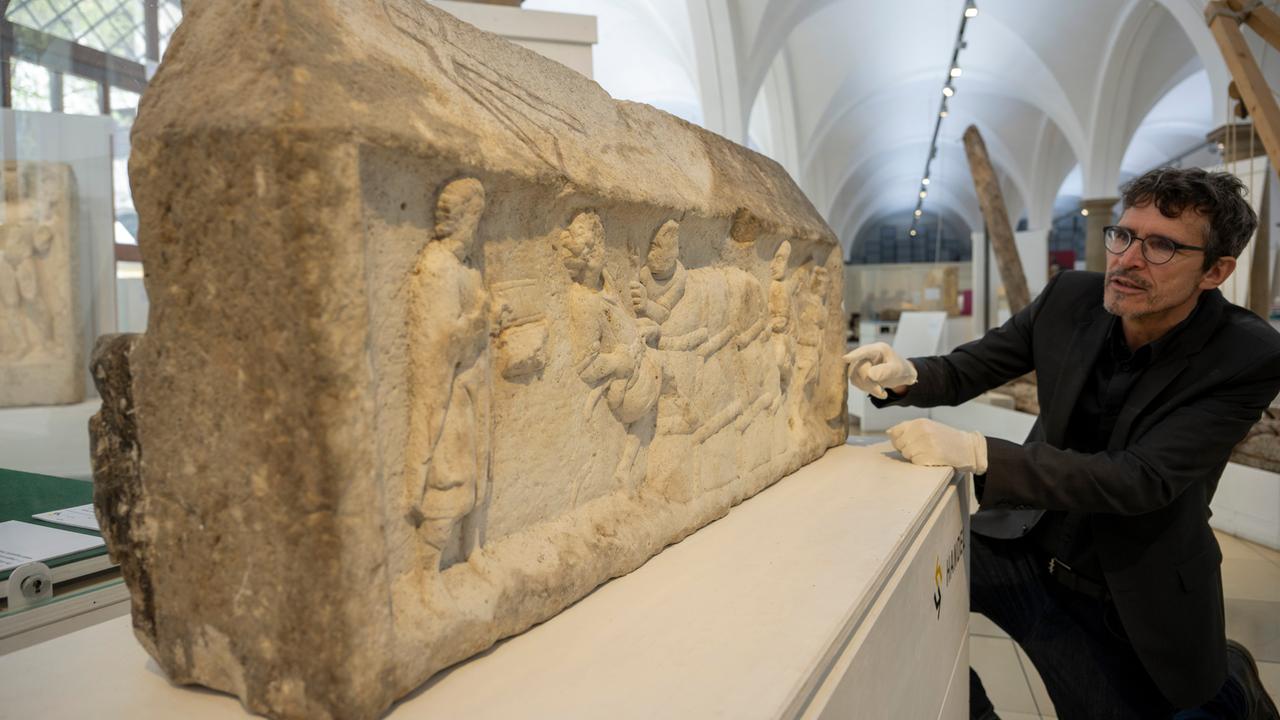 Ein großer Steinblock mit eingemeißelten Figuren: Die Augsburger Grabreliefs zeigen Motive aus dem Wein- und Textilhandel. 